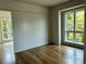 A serene bedroom with hardwood floors, neutral walls, and an oversized window with a lovely view at 1168 Queens Rd, Charlotte, NC 28207