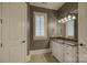 Bathroom with granite vanity, tiled floor, and a window with shutters at 16908 Ashton Oaks Dr, Charlotte, NC 28278