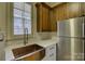 Laundry room with copper farm sink, wood cabinets, and quartz countertops at 16908 Ashton Oaks Dr, Charlotte, NC 28278