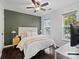 Bedroom with dark green accent wall, queen bed, and hardwood floors at 216 Devon Forest Dr, Mooresville, NC 28115