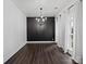 Elegant dining room featuring a chandelier and dark accent wall at 216 Devon Forest Dr, Mooresville, NC 28115