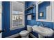 Small bathroom with blue walls, white sink and toilet, and floating shelves at 440 Luray Way, Rock Hill, SC 29730