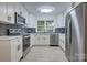 Modern kitchen features white cabinets, stainless steel appliances, and herringbone backsplash at 4601 Coronado Dr # C, Charlotte, NC 28212