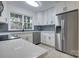 Modern kitchen with white cabinets, stainless steel appliances, and herringbone tile backsplash at 4601 Coronado Dr # C, Charlotte, NC 28212