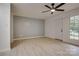 Living room features ceiling fan, light grey wall, vinyl plank flooring, and backyard view at 4601 Coronado Dr # C, Charlotte, NC 28212