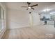 Bright living room with ceiling fan, vinyl plank flooring, and access to kitchen at 4601 Coronado Dr # C, Charlotte, NC 28212