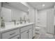 Well-lit bathroom featuring a large mirror, a single sink, and neutral-colored cabinets at 885 Exeter Dr, Sherrills Ford, NC 28673