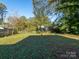 The grassy backyard, enclosed by a wooden fence, provides a private outdoor space with mature trees at 1411 Lineberger Ave, Gastonia, NC 28052