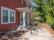 A view of the backyard featuring a brick home with white columns, with a gated driveway leading to the back at 1411 Lineberger Ave, Gastonia, NC 28052