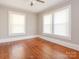 This bedroom features hardwood floors, natural paint, a ceiling fan, and windows for plenty of natural light at 1411 Lineberger Ave, Gastonia, NC 28052