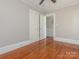 Bedroom with hardwood floors, neutral paint, and view into the hallway with railing visible to the staircase at 1411 Lineberger Ave, Gastonia, NC 28052