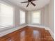 This is a spacious bedroom with hardwood floors, neutral paint, ceiling fan, and windows for natural light at 1411 Lineberger Ave, Gastonia, NC 28052