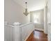 Hallway view with wood floors and a white banister leading to the upper level at 1411 Lineberger Ave, Gastonia, NC 28052