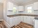 Kitchen view featuring white cabinetry, a stainless steel sink, and warm-toned flooring at 1411 Lineberger Ave, Gastonia, NC 28052