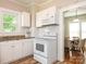 Kitchen view with white cabinetry, white appliances and a glimpse into an adjacent dining room at 1411 Lineberger Ave, Gastonia, NC 28052
