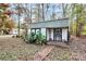 Exterior view of a white storage shed with black trim nestled in the woods at 2164 Mission Rd, York, SC 29745
