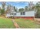 Well-maintained single-story home showcasing a manicured lawn, trimmed hedges, and a brick foundation at 2164 Mission Rd, York, SC 29745