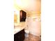 Well-lit bathroom featuring white tiled walls, brown cabinets, and a shower-tub combination at 206 Swaim Ct, Salisbury, NC 28147