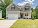 Charming two-story home featuring a two-car garage, craftsman details, and manicured front lawn at 2387 Trundle Dr # Cwo0155, Gastonia, NC 28054