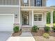 Front entrance with covered porch, brick accents, and gray siding, alongside a white garage door at 2387 Trundle Dr # Cwo0155, Gastonia, NC 28054