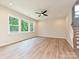 Living room featuring hardwood floors, large windows, and a staircase with white risers at 2387 Trundle Dr # Cwo0155, Gastonia, NC 28054