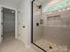 Glass-enclosed shower with gray tiled walls and river rock floor, next to a doorway to a closet at 2387 Trundle Dr # Cwo0155, Gastonia, NC 28054