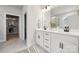 Bright bathroom with double sinks, white cabinets, black hardware, marble floors, and an open closet at 3118 Whispering Creek Dr, Indian Trail, NC 28079