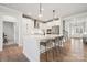 Bright, modern kitchen with a large island, stainless steel appliances, and an adjacent staircase at 3118 Whispering Creek Dr, Indian Trail, NC 28079