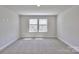 Spacious bedroom with neutral carpet, light gray walls, and double windows letting in natural light at 115 Ciara Pl # B, Mooresville, NC 28117