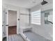 Modern glass shower featuring built-in bench, marble tile surround, and glass block window at 18023 Train Station Dr, Cornelius, NC 28031