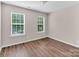 Bedroom with hardwood floors, two windows, and a view at 18023 Train Station Dr, Cornelius, NC 28031