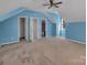 Spacious bedroom with blue accent wall, plush carpet, and three doors at 18023 Train Station Dr, Cornelius, NC 28031