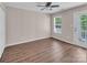 Bedroom with hardwood floors, a ceiling fan, a window with a view, and a door to the outside at 18023 Train Station Dr, Cornelius, NC 28031