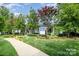 A charming white clubhouse featuring a welcoming porch and lush landscaping at 18023 Train Station Dr, Cornelius, NC 28031