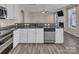 A kitchen featuring stainless steel appliances, white cabinets, granite countertops and wood-look flooring at 18023 Train Station Dr, Cornelius, NC 28031