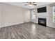 Living room featuring wood-look floors, neutral paint, a fireplace, and plenty of natural light at 18023 Train Station Dr, Cornelius, NC 28031