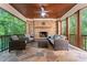 Inviting covered patio features a stone fireplace, wood ceiling and comfortable seating at 20361 Enclave Oaks Ct, Cornelius, NC 28031