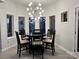 Elegant dining room with statement light fixture, complemented by large windows and modern decor at 20361 Enclave Oaks Ct, Cornelius, NC 28031