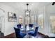Elegant dining room with a glass table, stylish blue chairs, and natural light at 20361 Enclave Oaks Ct, Cornelius, NC 28031