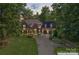 Lovely house with lush landscaping, stone accents, and a spacious driveway in a wooded setting at 20361 Enclave Oaks Ct, Cornelius, NC 28031