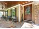 Inviting front porch with stone flooring, comfortable seating, and a stylish wooden door at 20361 Enclave Oaks Ct, Cornelius, NC 28031