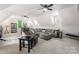 Spacious living room with vaulted ceilings, fan, and comfortable gray sectional sofa and view of the backyard at 20361 Enclave Oaks Ct, Cornelius, NC 28031