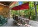 Outdoor patio with stone siding, a dining table, and wooded views at 20361 Enclave Oaks Ct, Cornelius, NC 28031