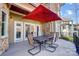 Outdoor dining space on deck with large red umbrella, offering shade for entertaining at 20361 Enclave Oaks Ct, Cornelius, NC 28031