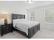 Bright bedroom with a dark wood bed frame, side table, and windows for natural light at 122 W Heart Pine Ln, Statesville, NC 28677