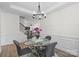 Bright dining room with a glass table, chandelier, wainscoting and views to the stairwell and living room at 122 W Heart Pine Ln, Statesville, NC 28677