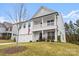 Two story home featuring a welcoming front porch and lush green lawn at 122 W Heart Pine Ln, Statesville, NC 28677