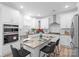 Modern kitchen with white cabinets, stainless steel appliances, and an island with seating, ideal for cooking and entertaining at 122 W Heart Pine Ln, Statesville, NC 28677