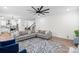 Open-concept living room with hardwood floors, neutral sofa, ceiling fan, and an inviting space for relaxation and entertainment at 122 W Heart Pine Ln, Statesville, NC 28677