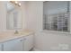 Small bathroom with vanity, mirror, and window blinds at 3312 Heathstead Pl, Charlotte, NC 28210